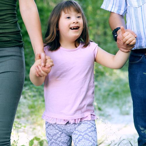 Young person walking while holding hands with an adult